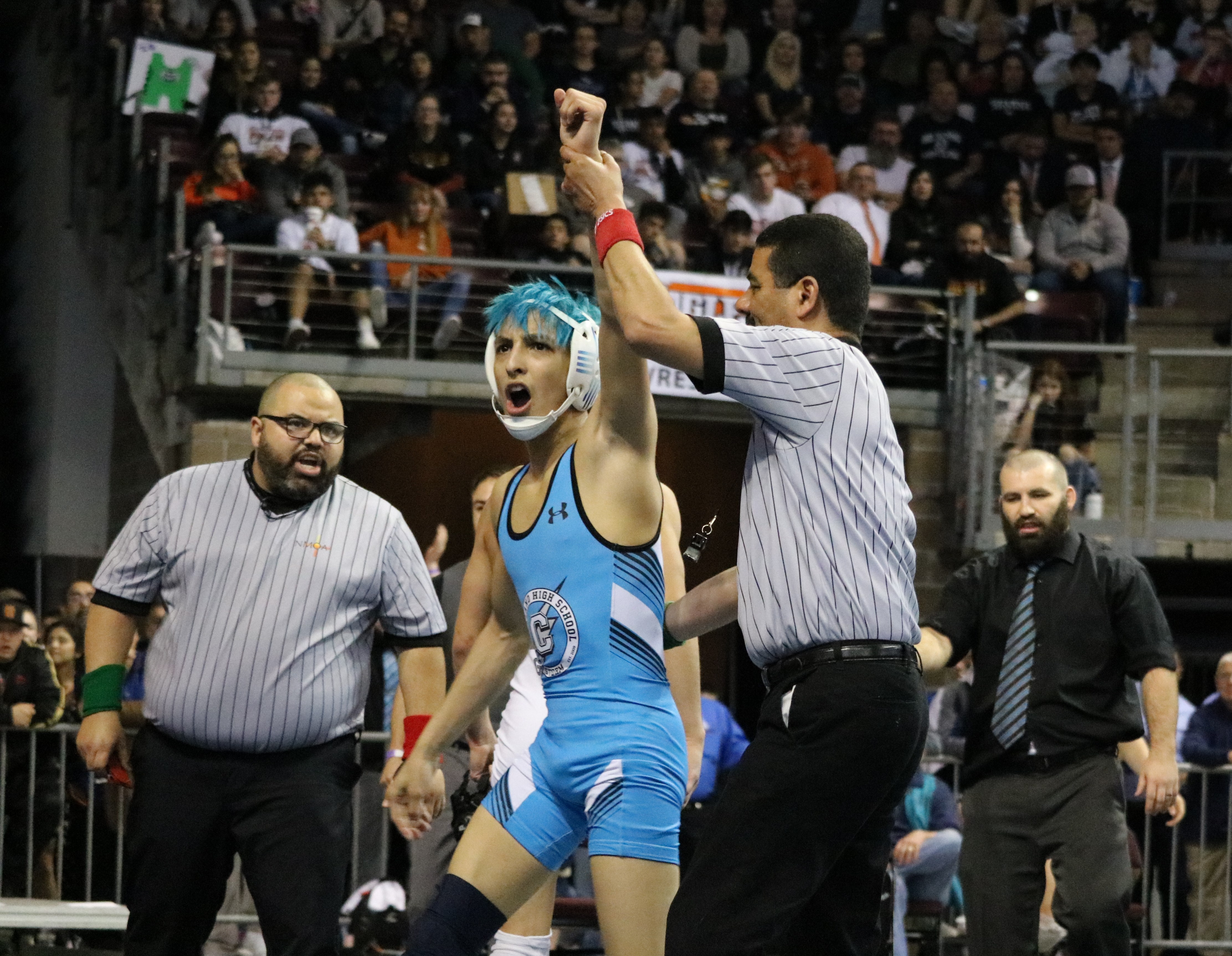 Cleveland wrestler holding hand up in the air with his victory