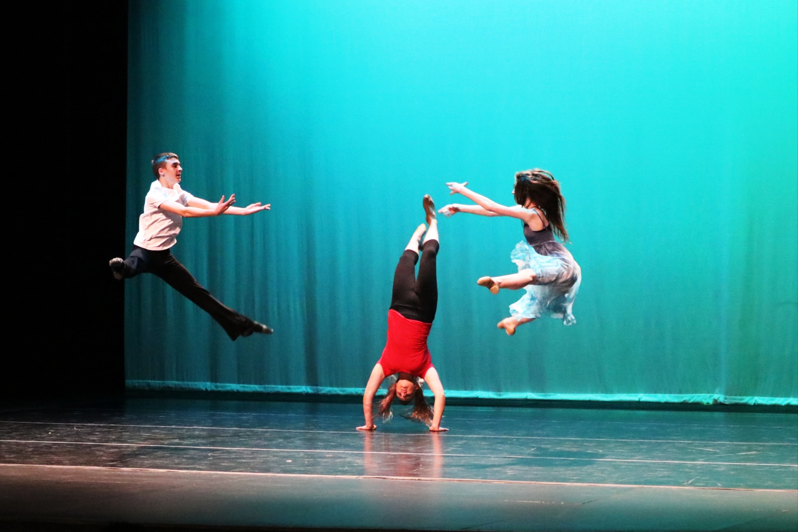 Fine Arts- Dancers flying in through the air on stage during a performance