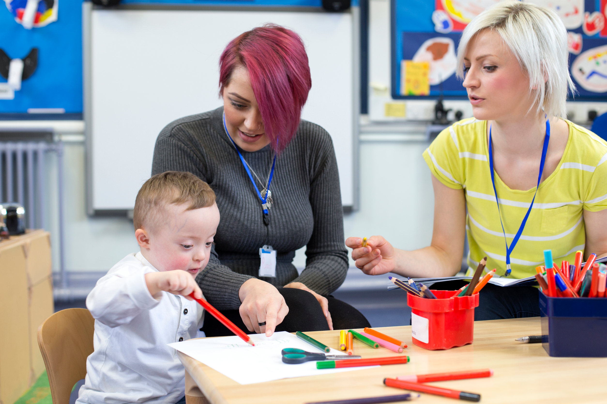 A special education teacher working one-on-one with a student at an table.