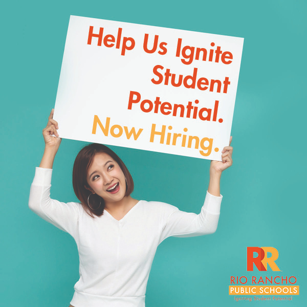 Woman holding a sign that says "Help Us Ignite Student Potential. Now Hiring."