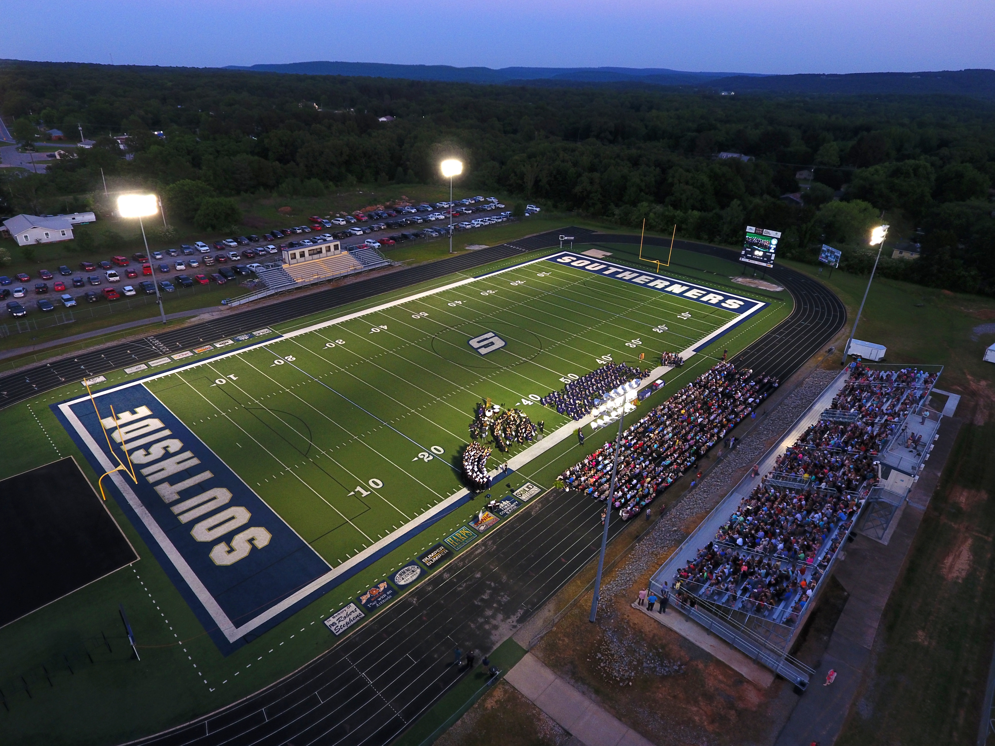 Drone view of the Southside Southerner football stadium at twilight, with students gathering on the field