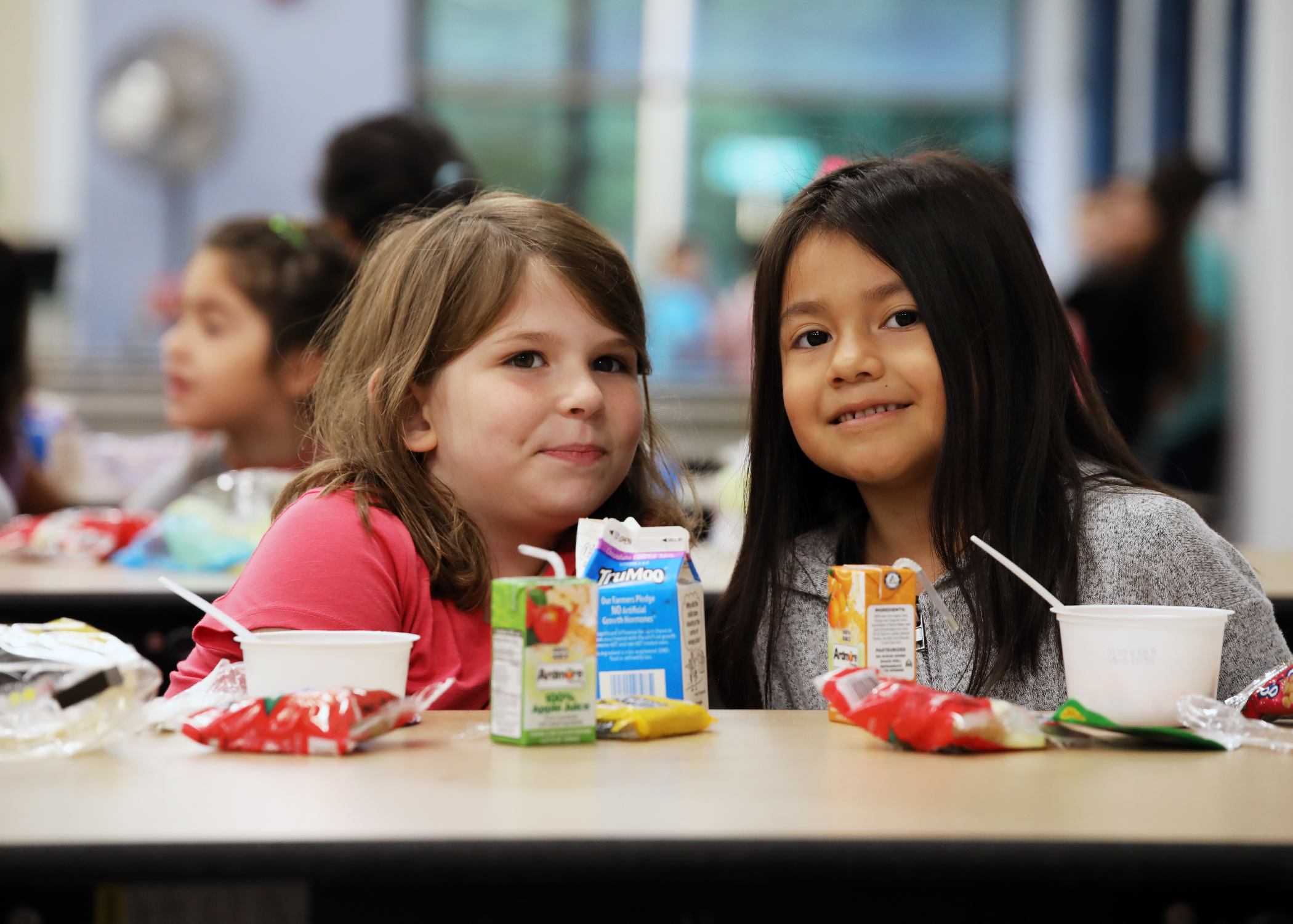 Two children pose for a picture in the cafeteria