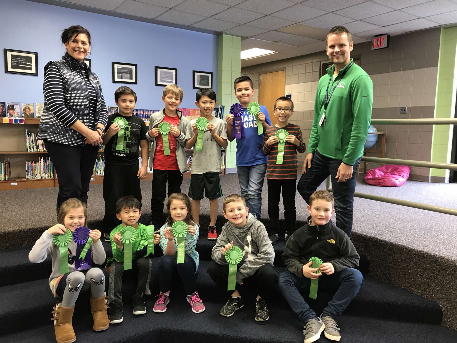 Small group of students with ribbons and 2 staff members