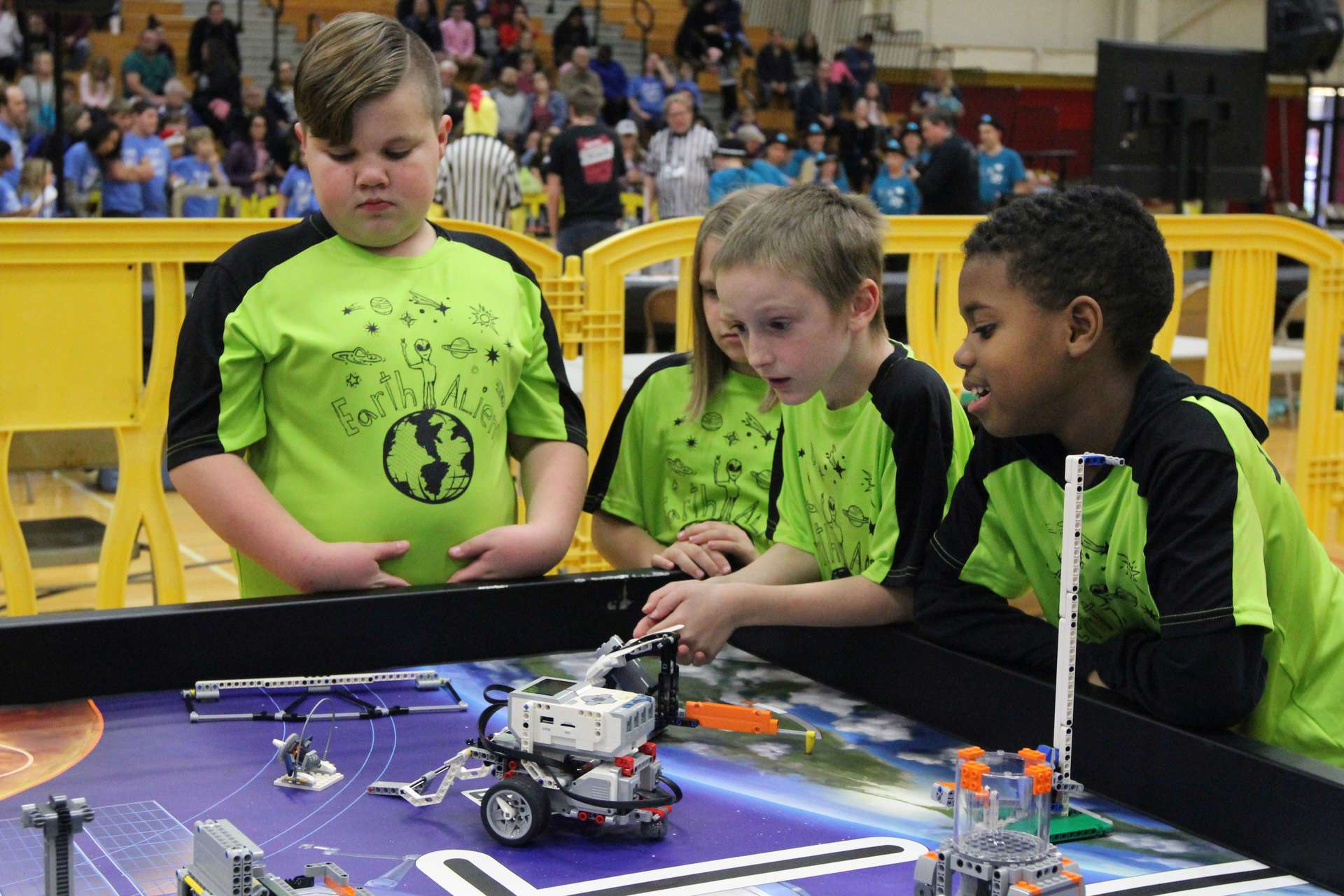 Students looking at small robots on a table