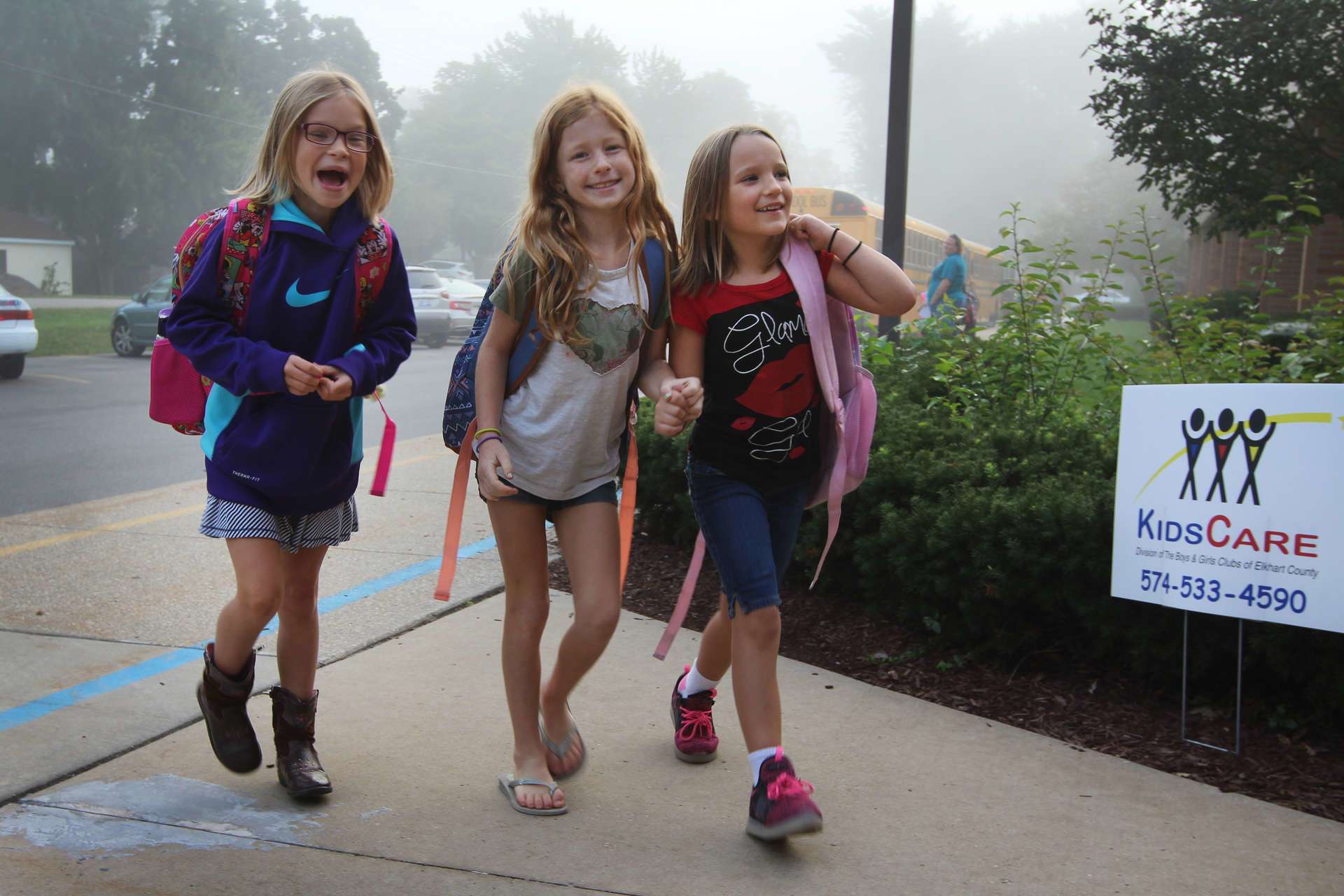 Three young girls walking to school together