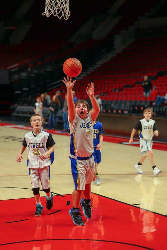 Student shooting the basketball into the hoop.