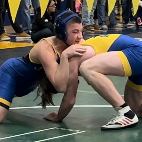Two students wrestling at a school wrestling match.