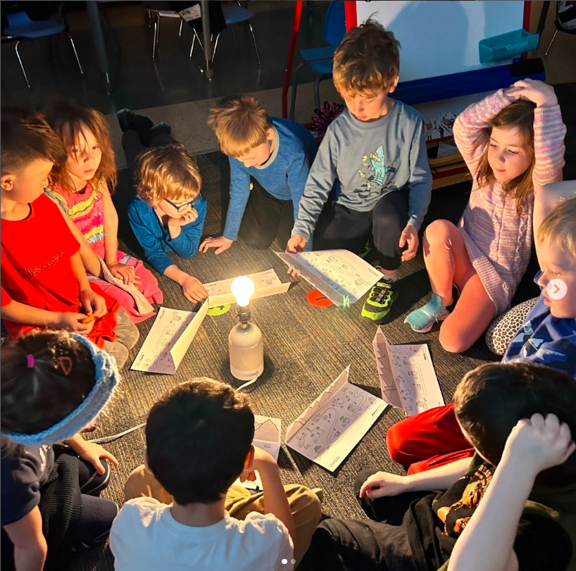 Students gathered around a lamp