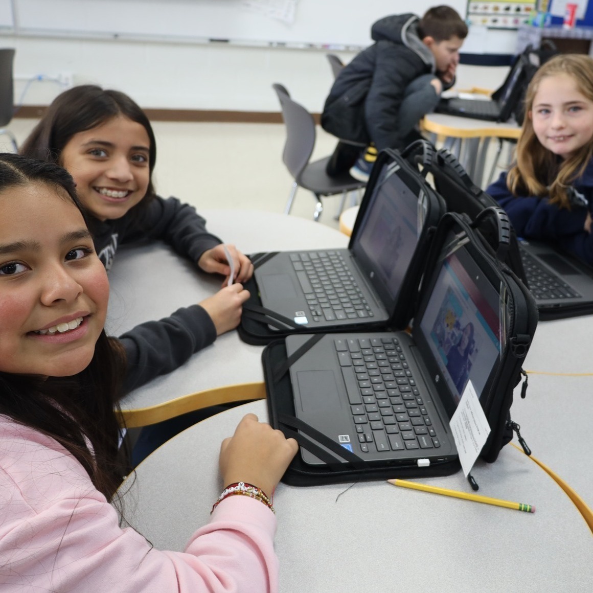 Students using laptops smiling