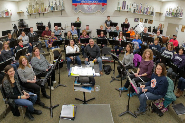 people holding instruments sitting in a band room