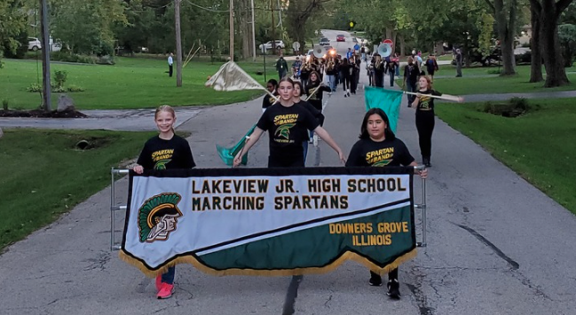 band marching with sign for Lakeview Jr. High School Marching Spartans