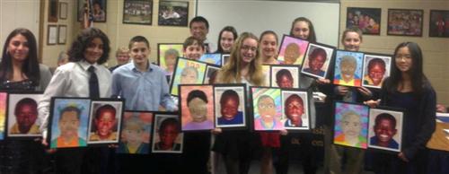 Students holding up portrait artwork