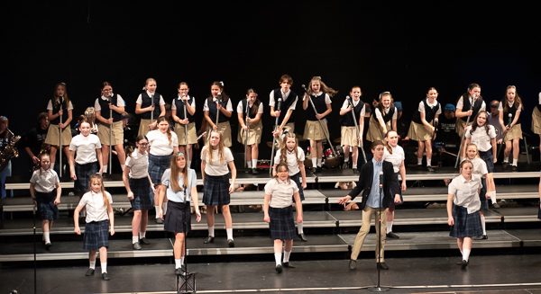 Next Edition Jr High Show Choir students performing on stage in costume