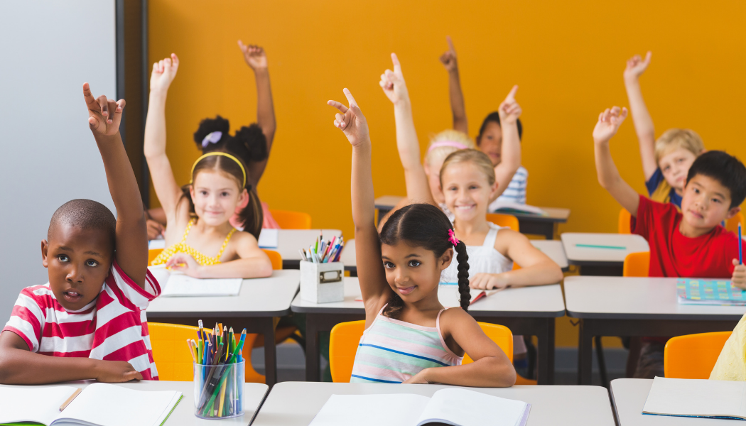 kids in class raising hands
