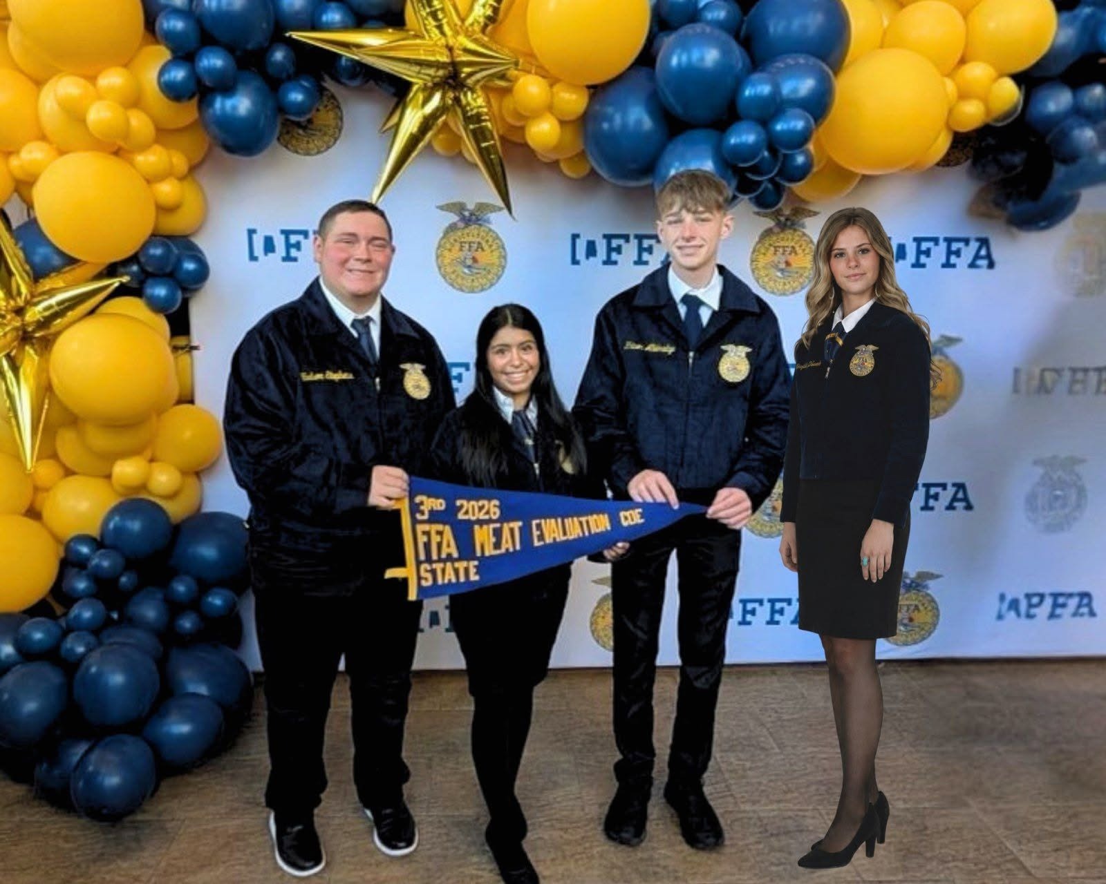 Four individuals in uniforms and black attire standing behind a balloon arch, holding a blue banner.