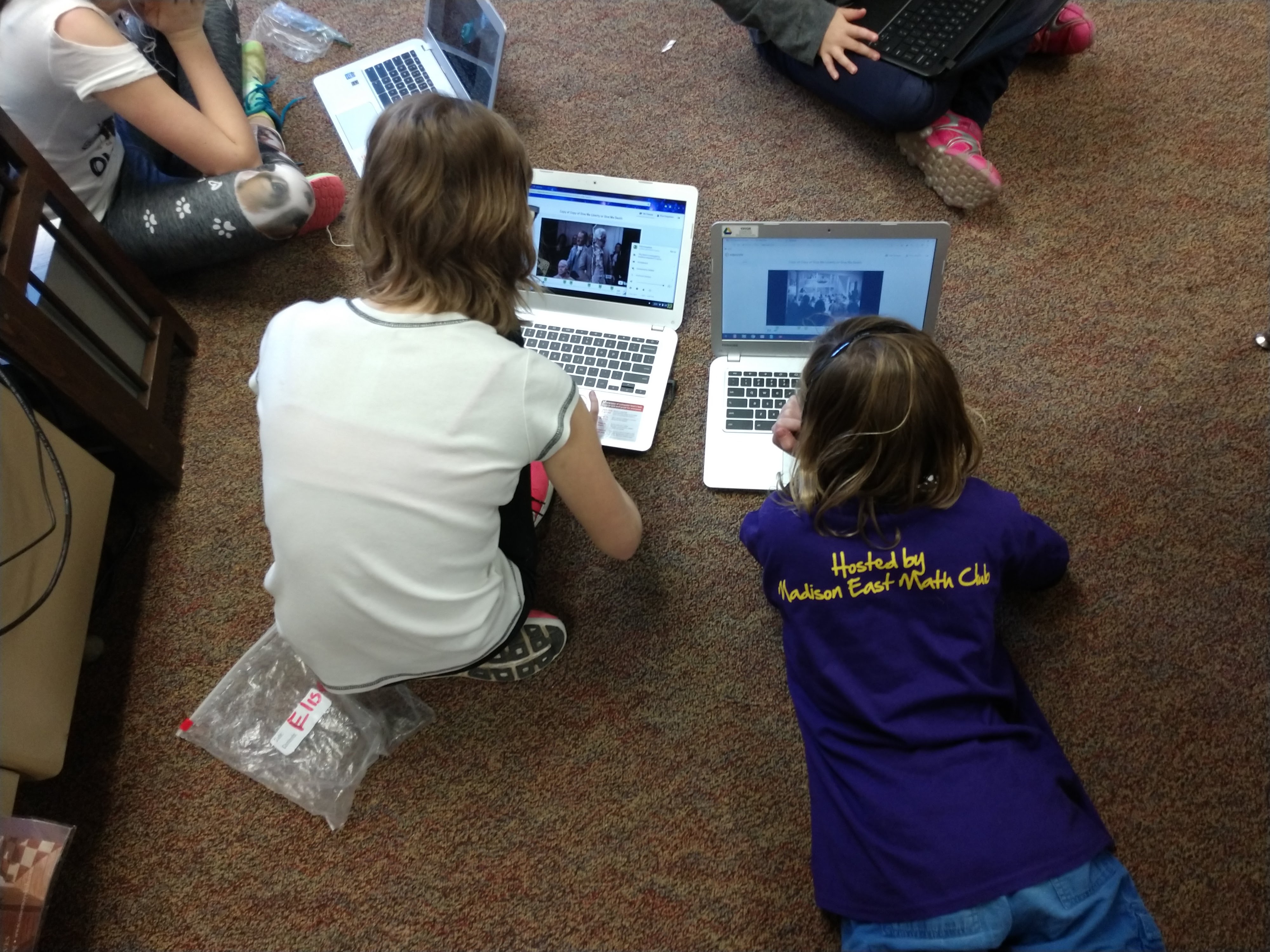 students on floor with Chromebooks