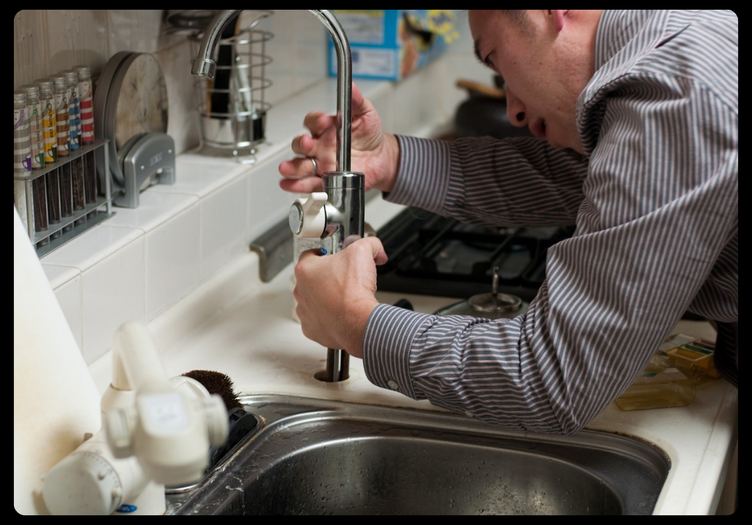 Plumber installing a faucet
