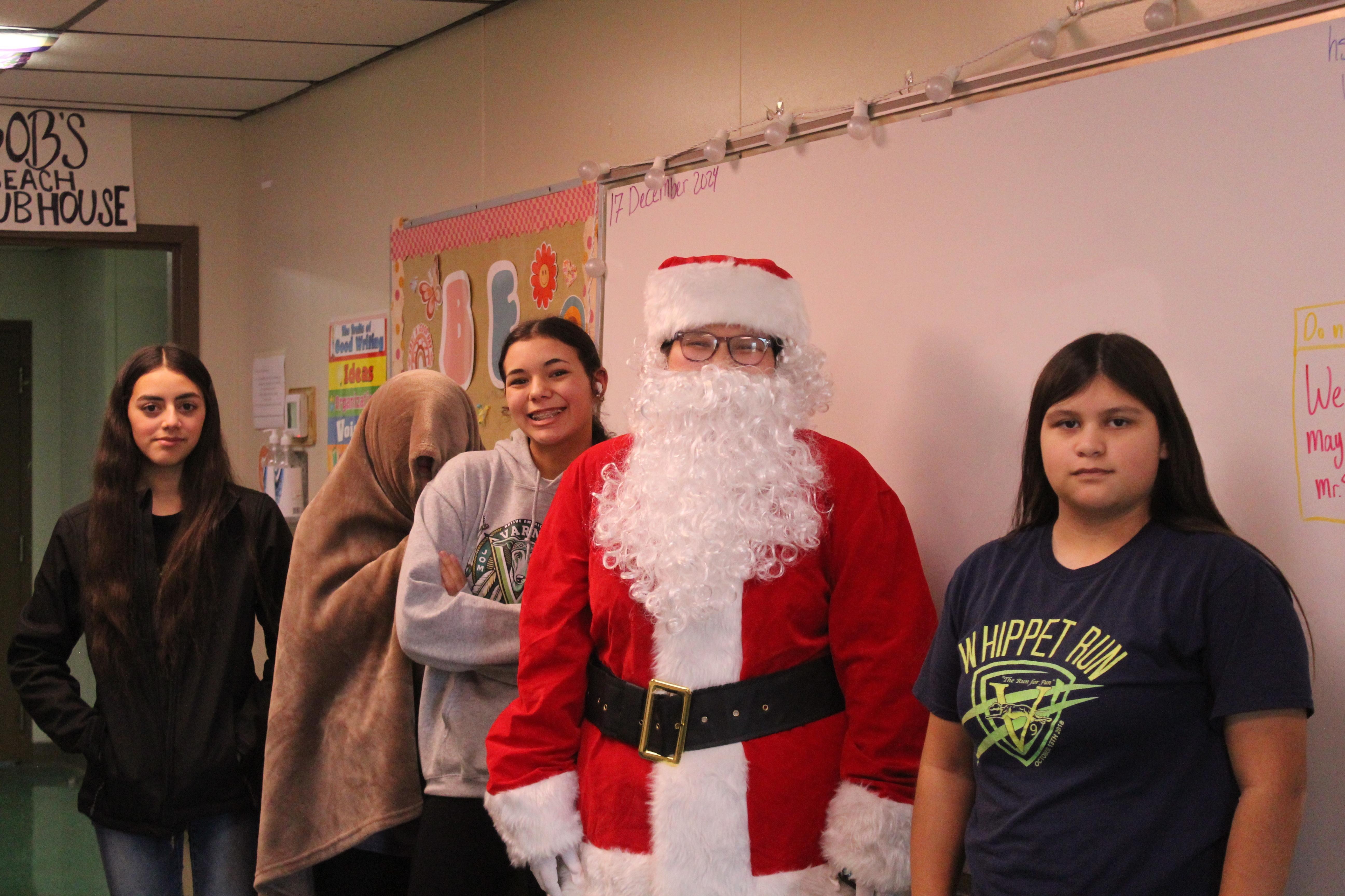 Journalism members posing with Santa for Christmas. From left to right Sophomore Dalia Marquez, Freshman Nevaeh Hare with her blanket, Freshman Madi Lewis, and Freshman Izabelle Delarosa. 