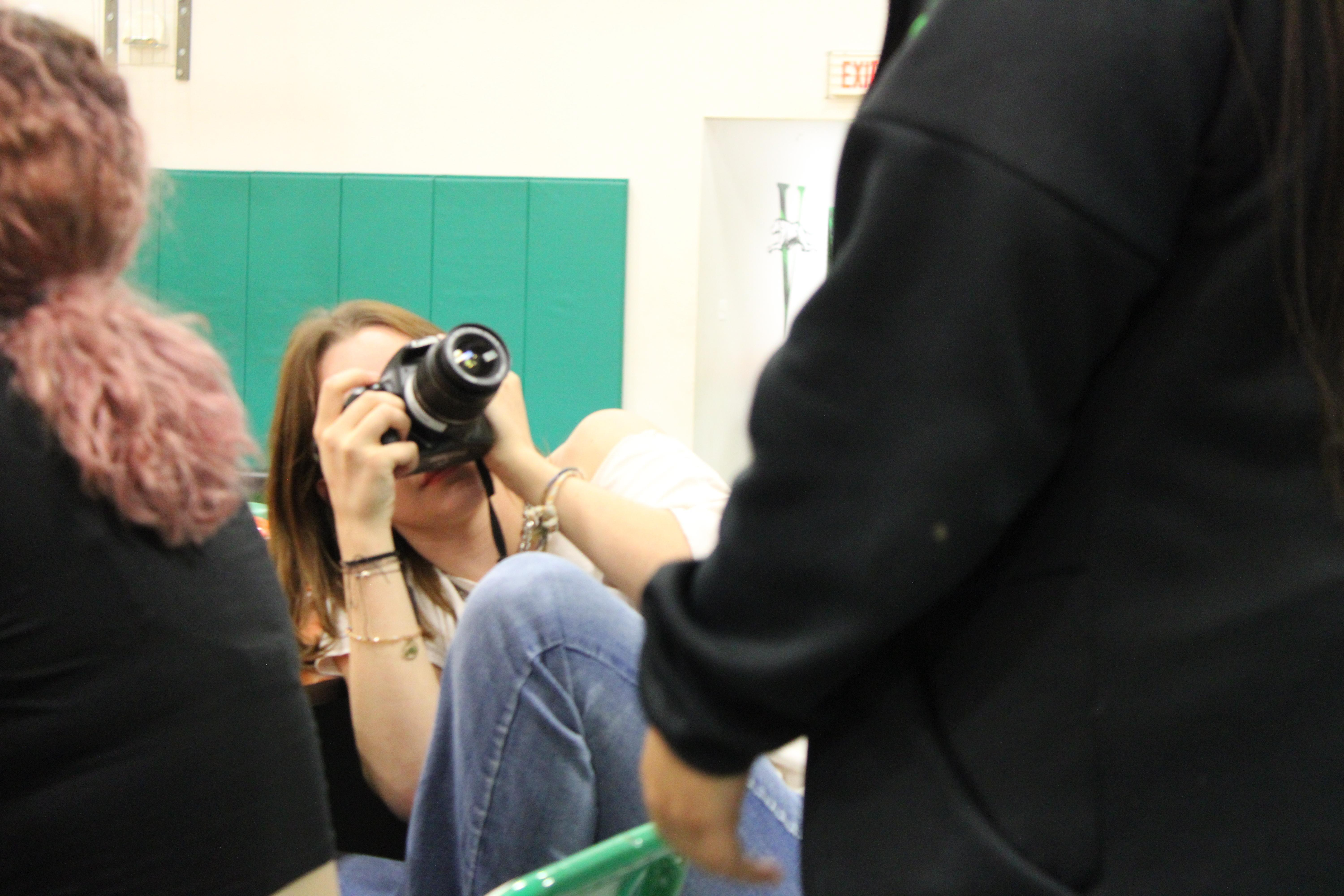 Journalism staff member  Junior Faith Cornett taking candids during practice. 