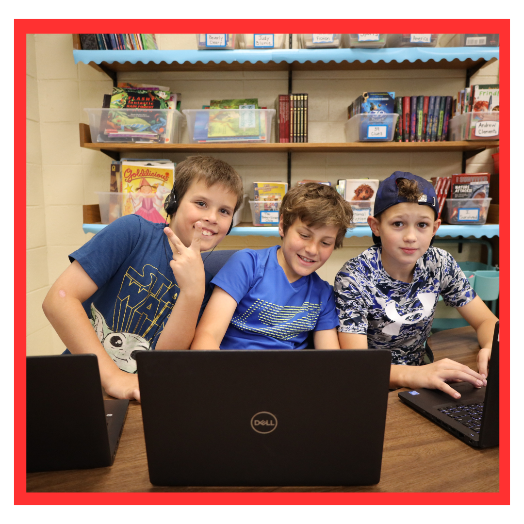 three boys with laptops