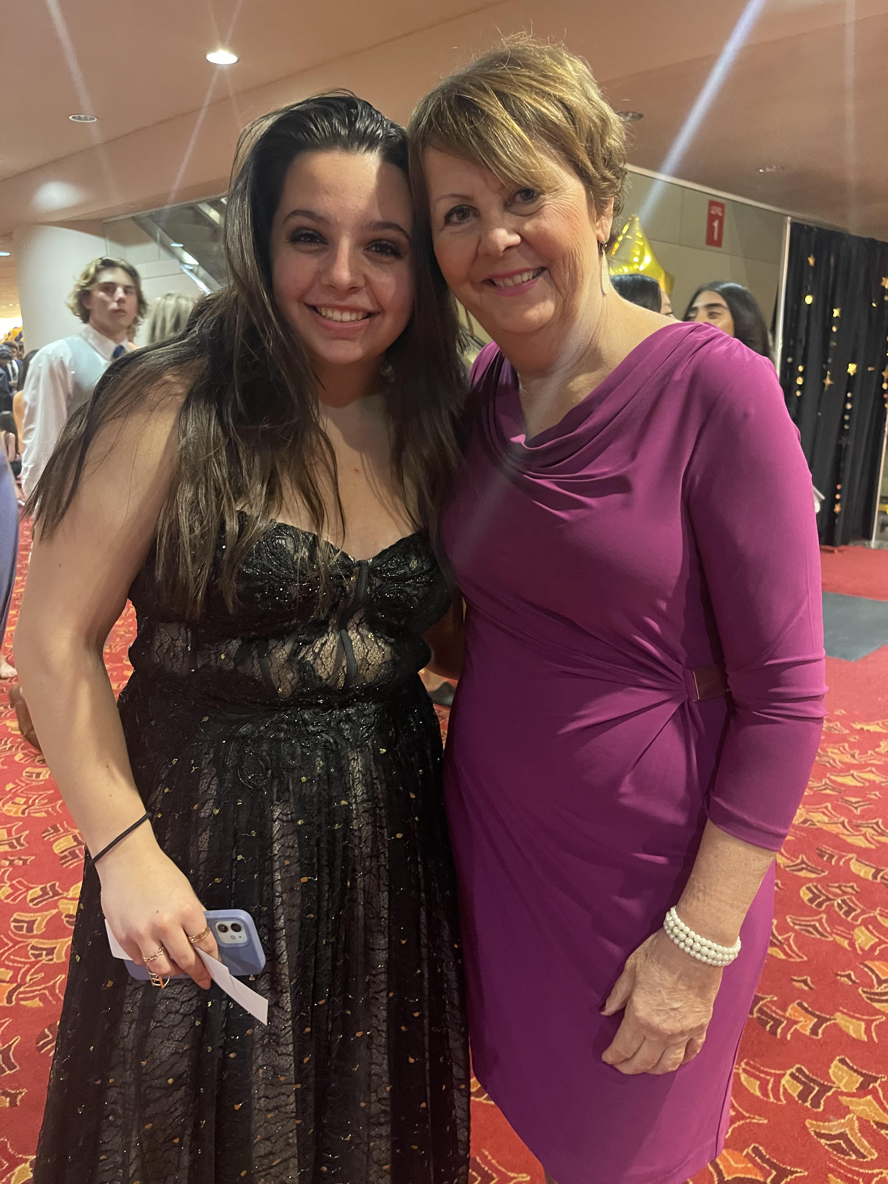 peg shoemaker taking a picture with a student at the prom