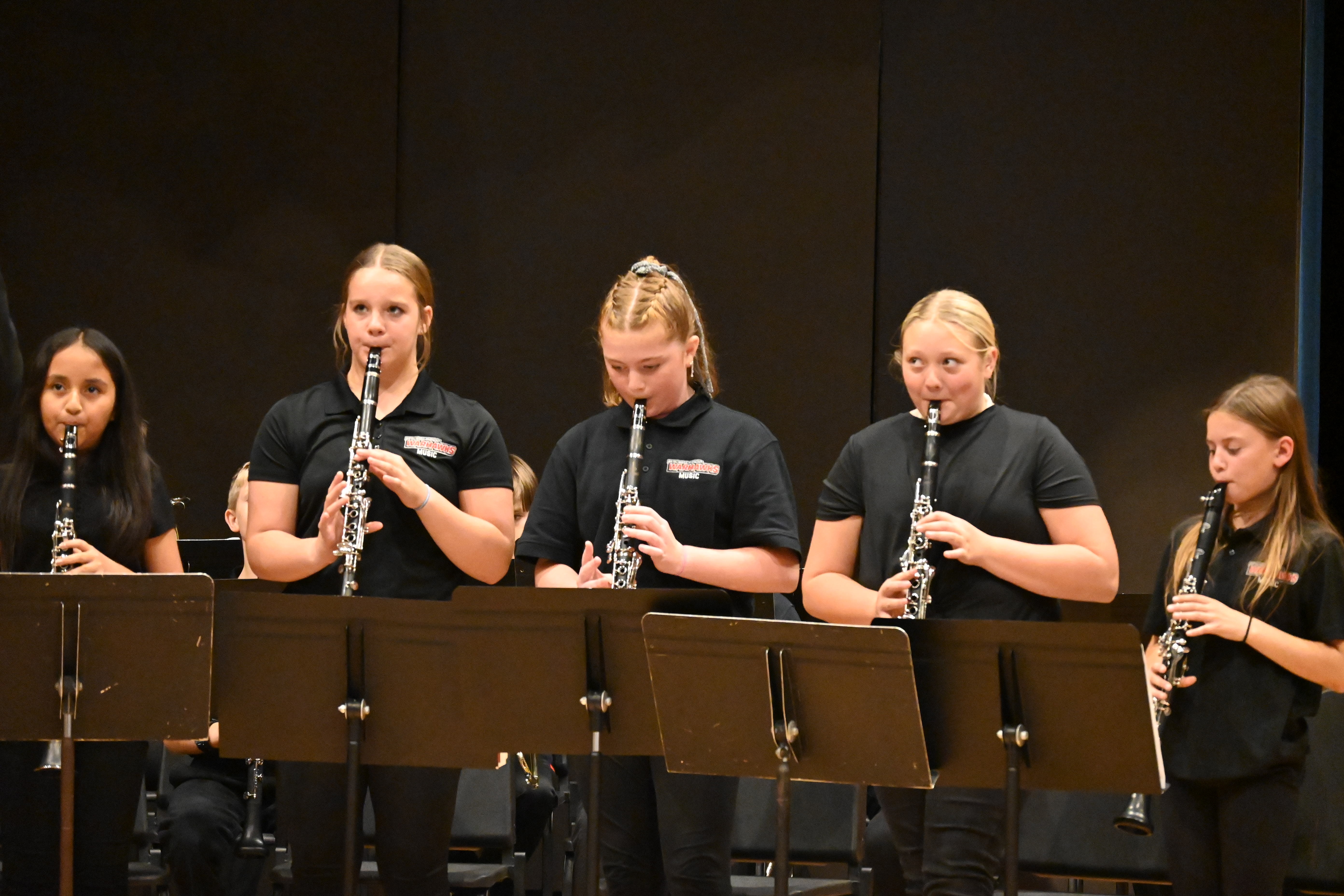 6th grade band playing instruments at concert.