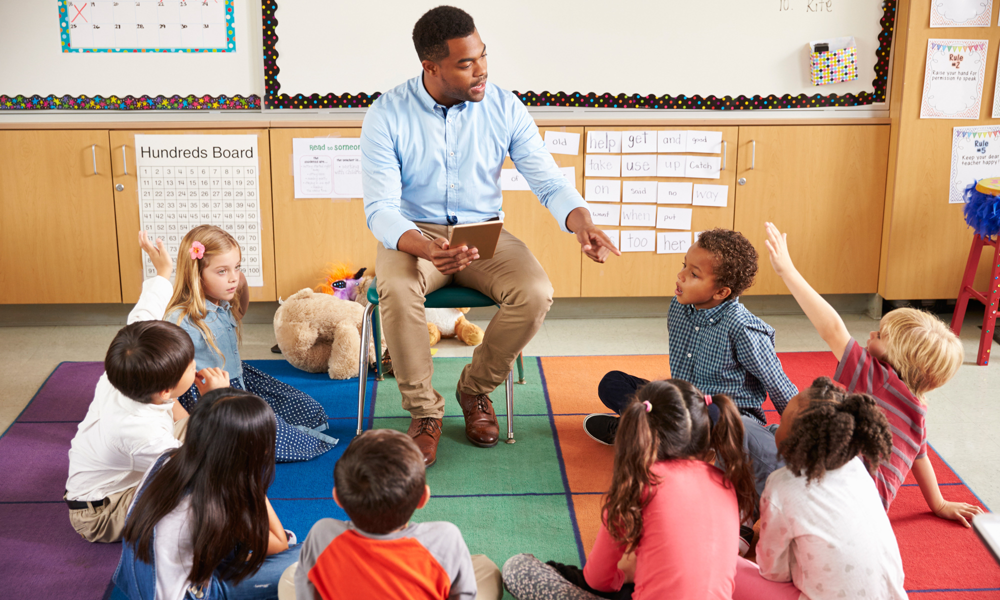 A picture of a male teacher in a elementary classroom