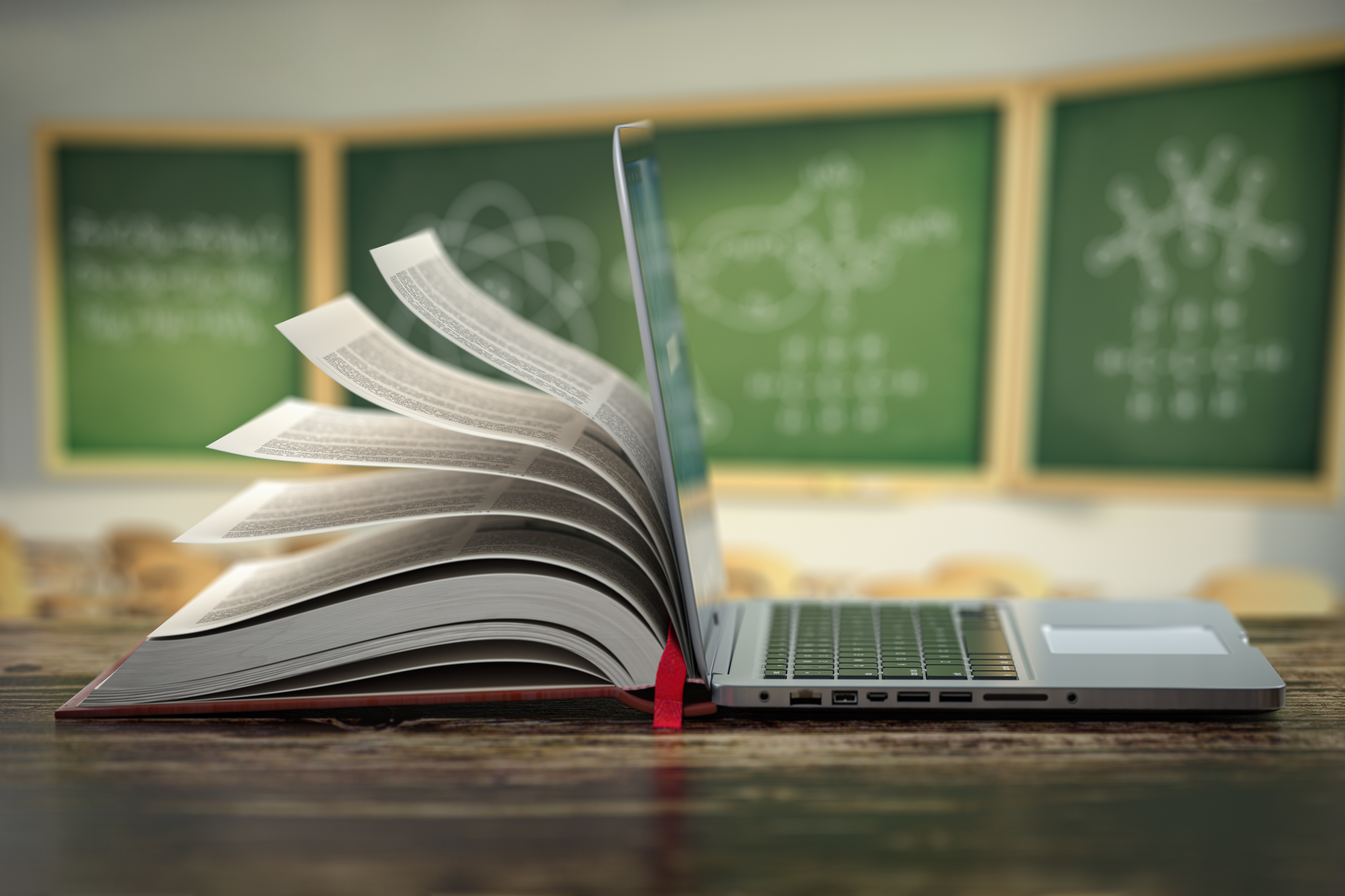 Laptop with a book behind it