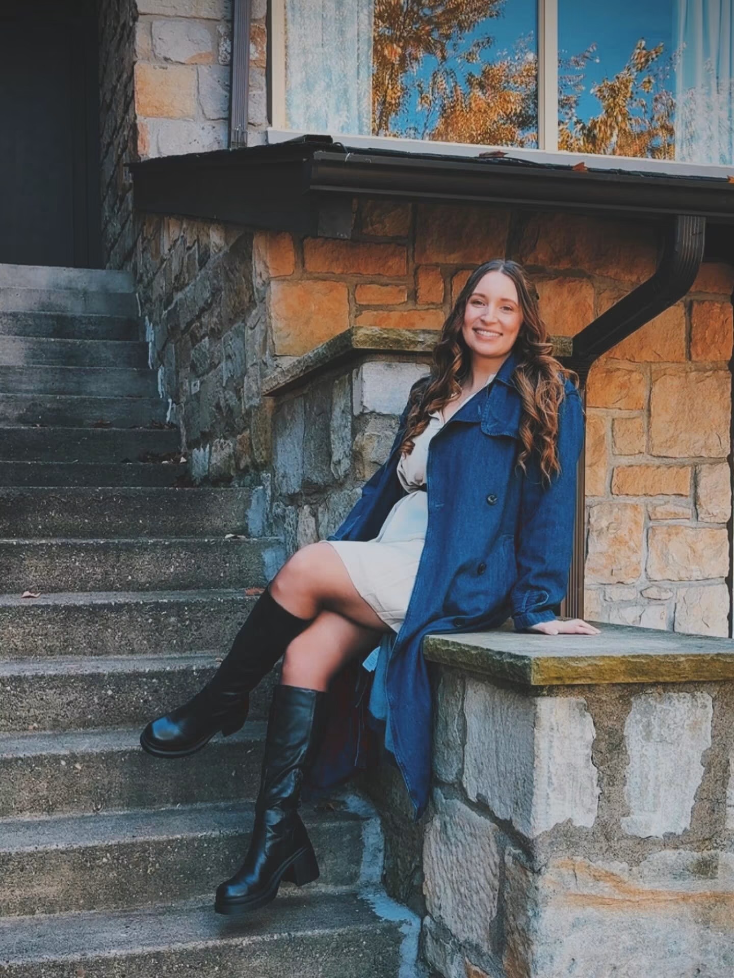 Personal portrait: Tiffany Clemins, Secondary Instructional Technology Coach, smiling while seated outdoors beside a stone building.