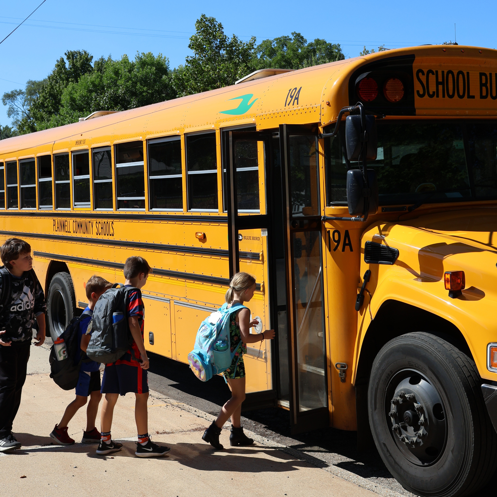 Picture of four students boarding a school bus