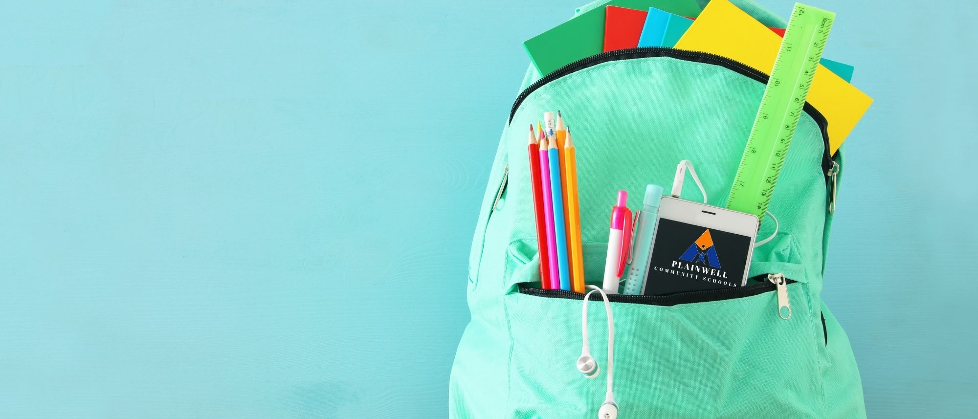 Picture of backpack with various school supplies (notebooks, pencils, cell phone with PCS logo, headphones)