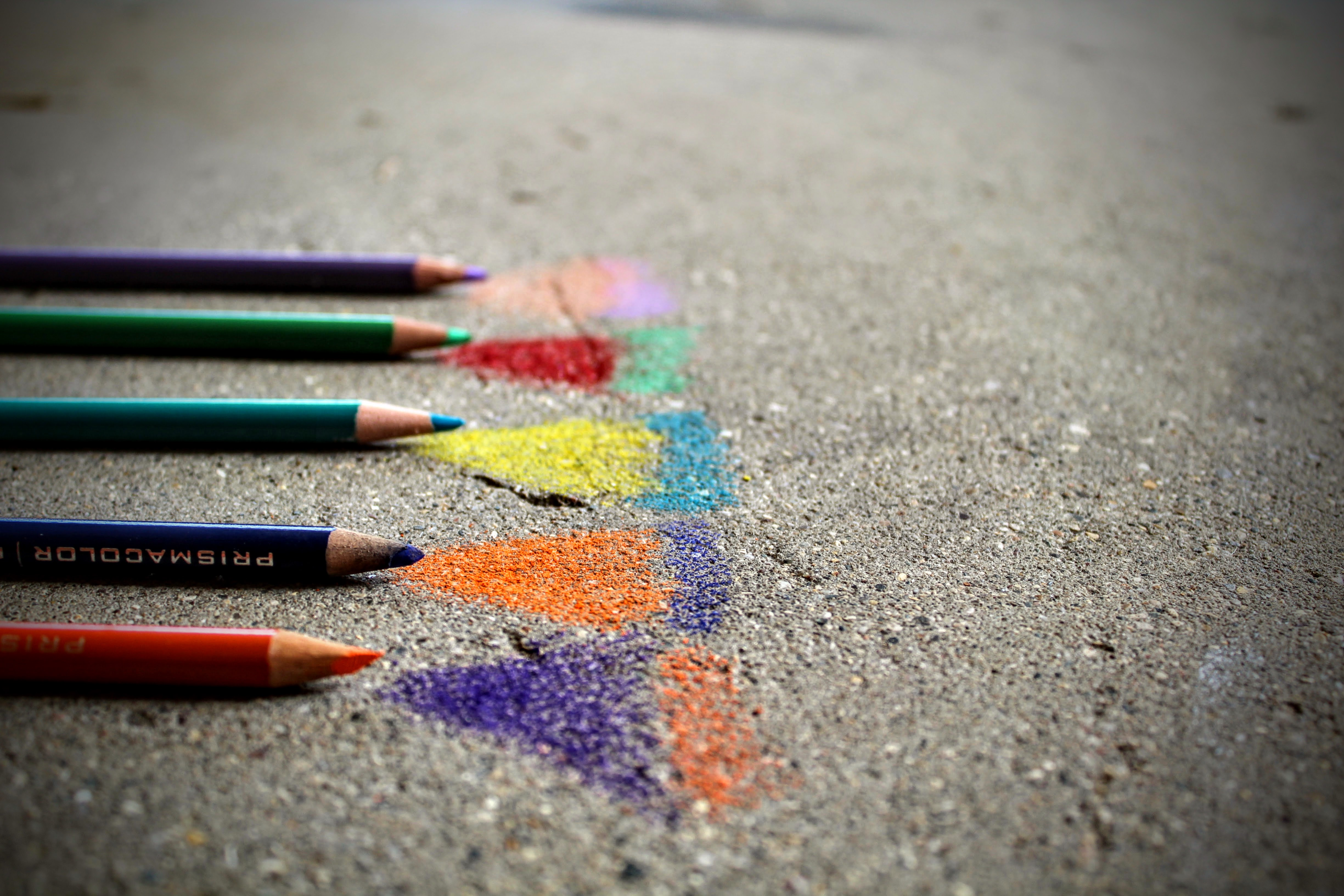 Colored pencils on sidewalk with various colored triangles