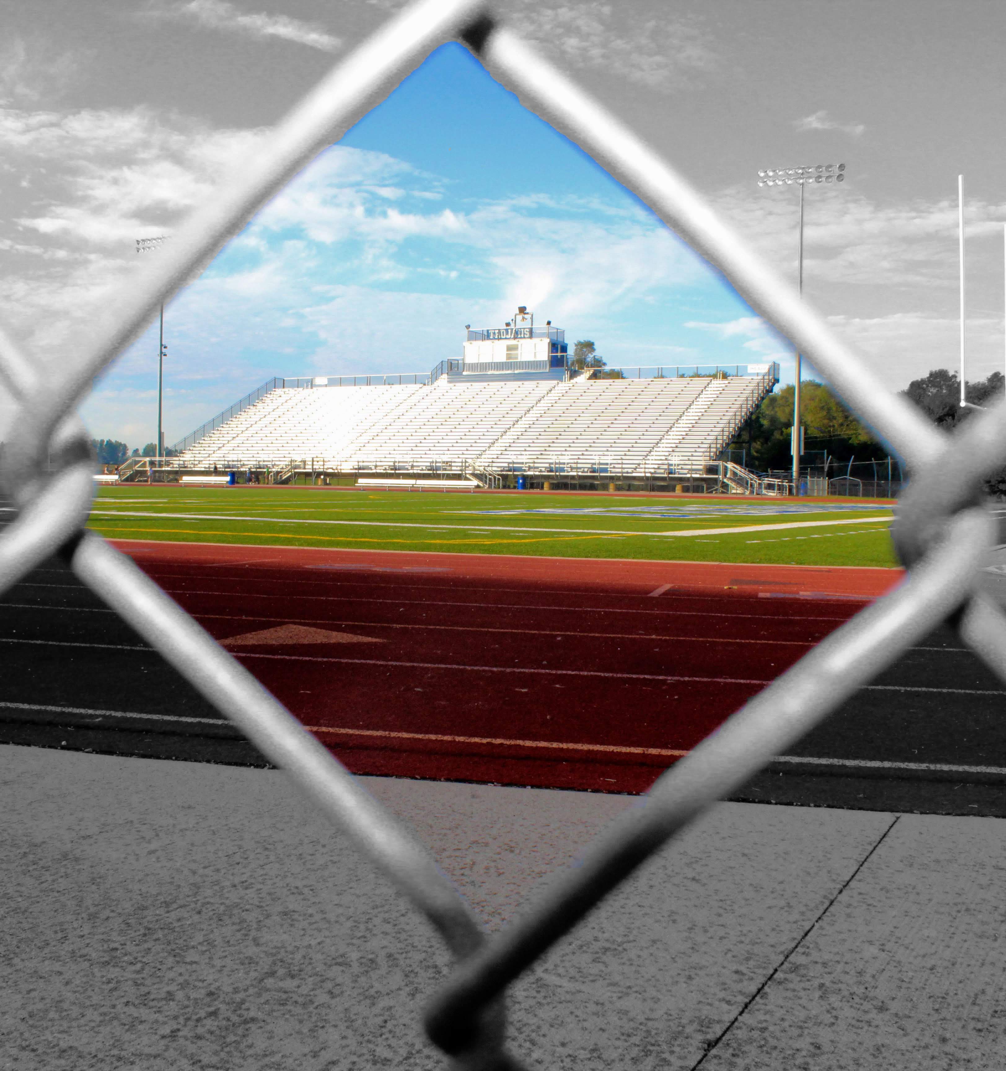 Picture of football stadium looking through chain link fence