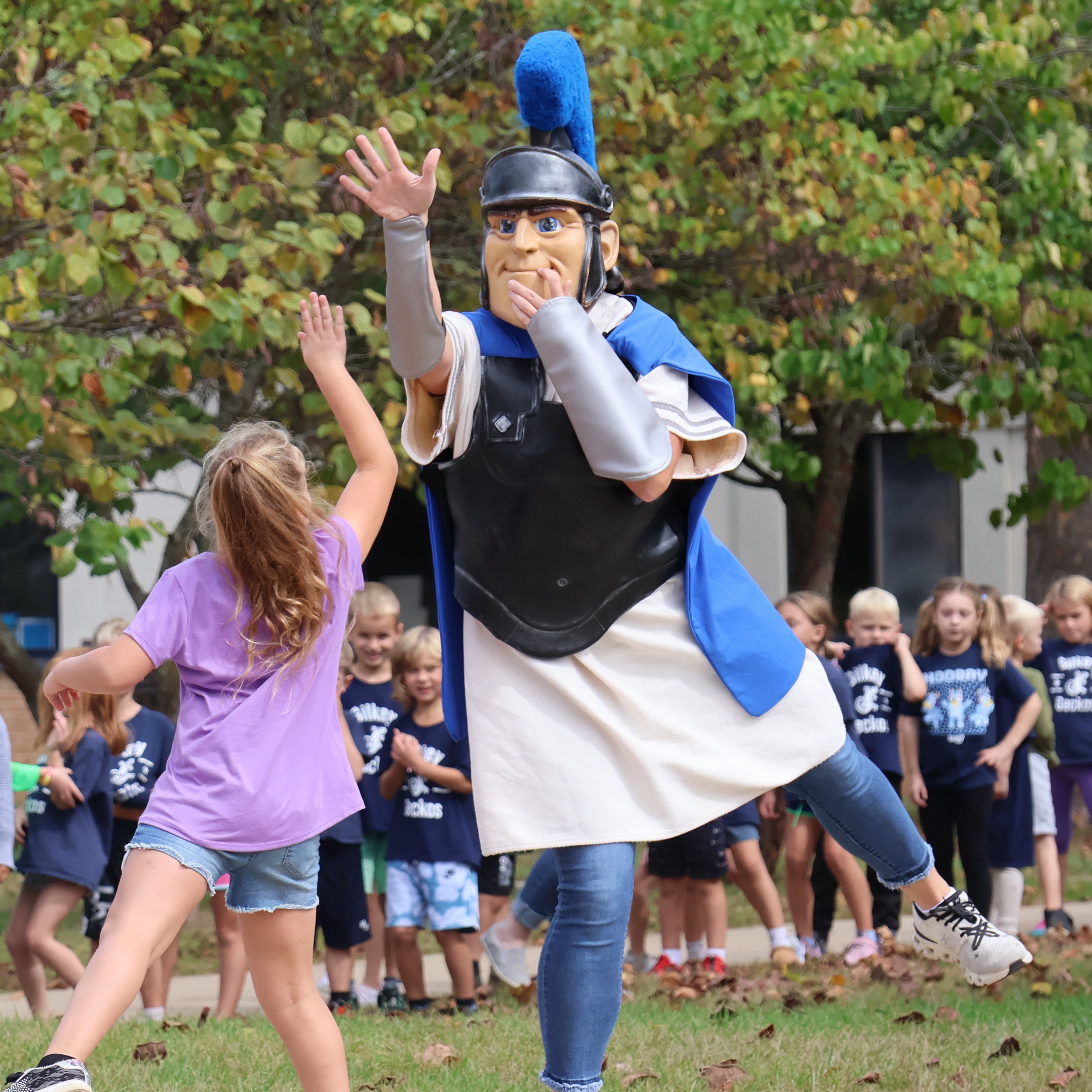 Picture of Trojan mascot giving a high five to a student
