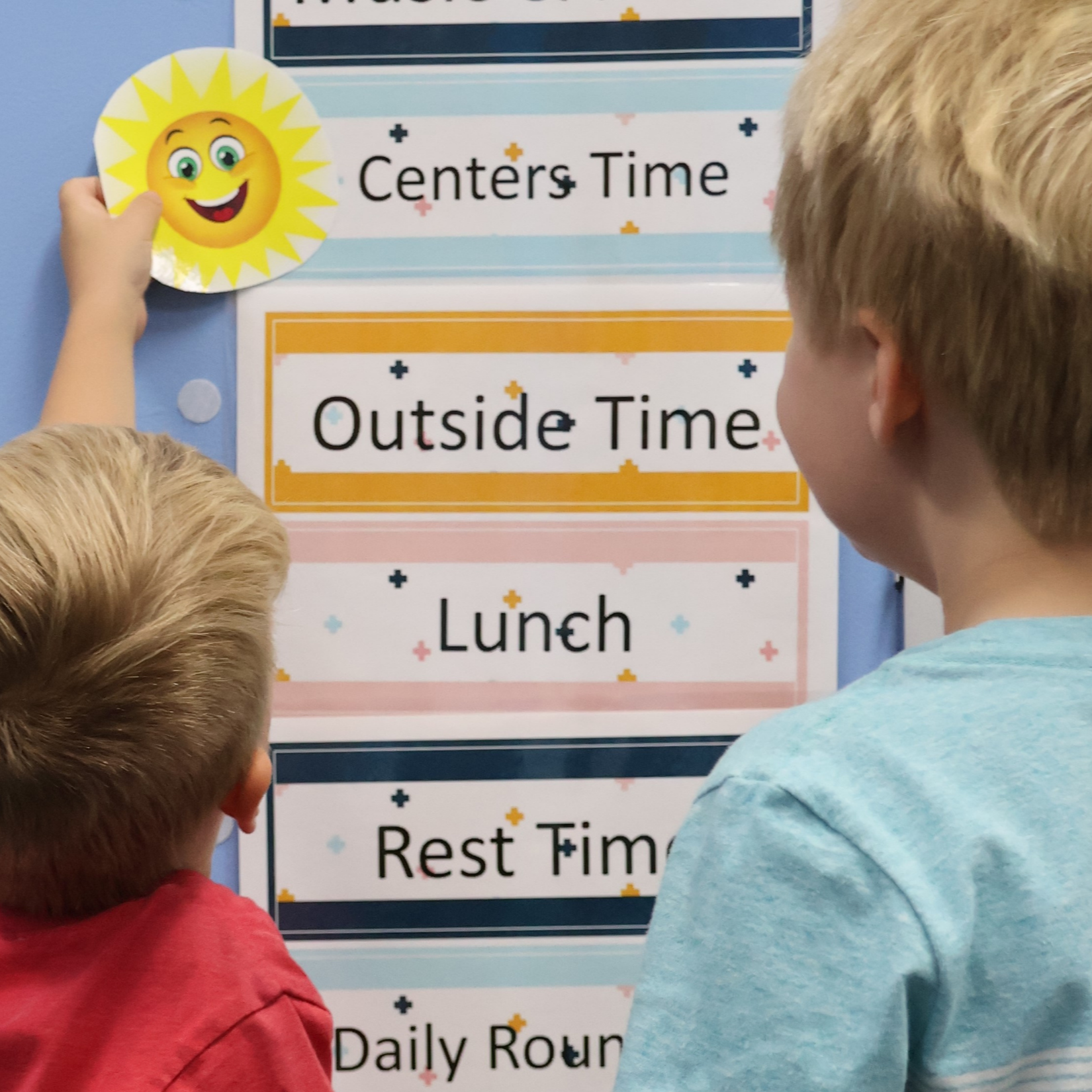 Picture of two preschool students picking an activity from their activity chart