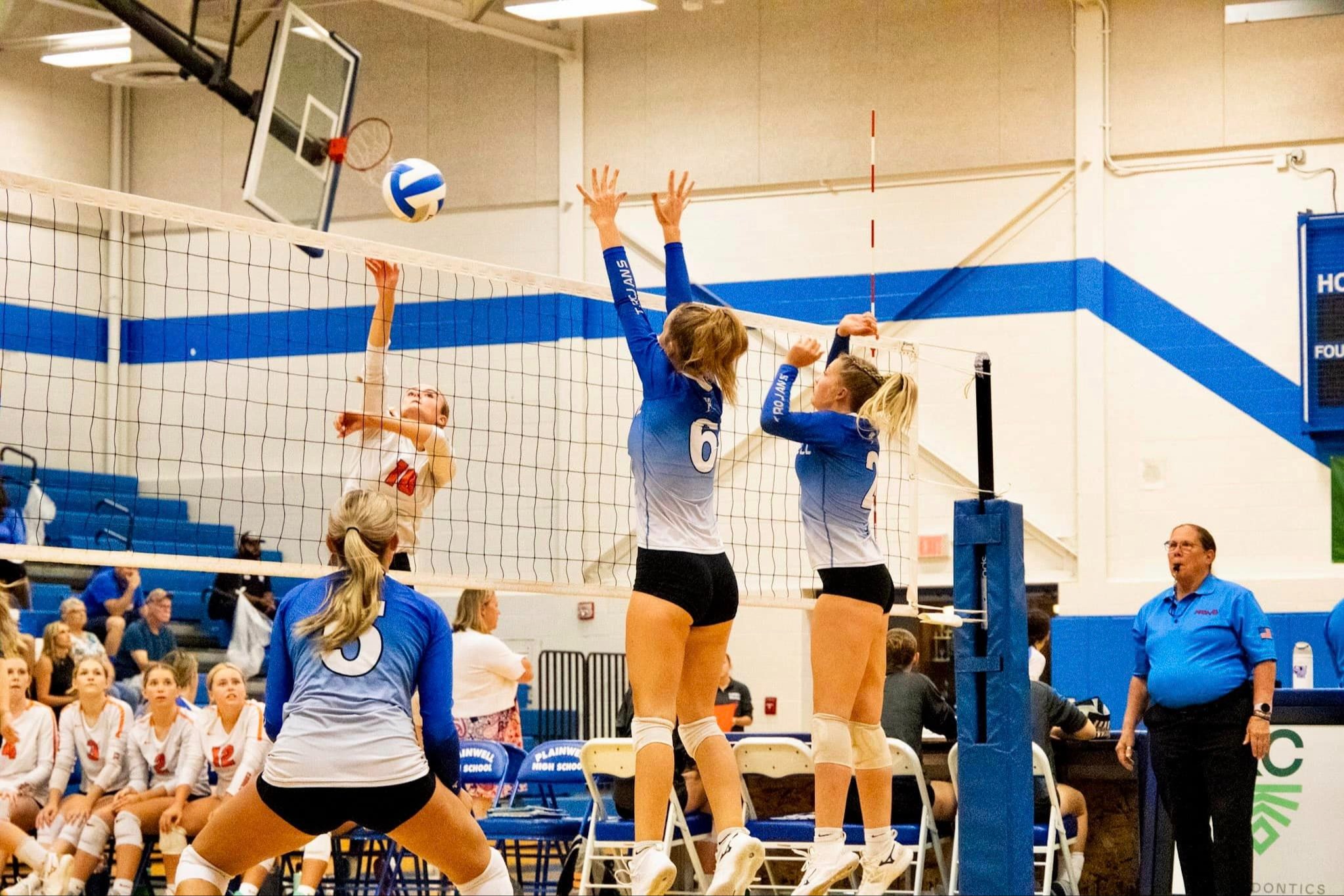 Picture of three trojan volleyball players during a match