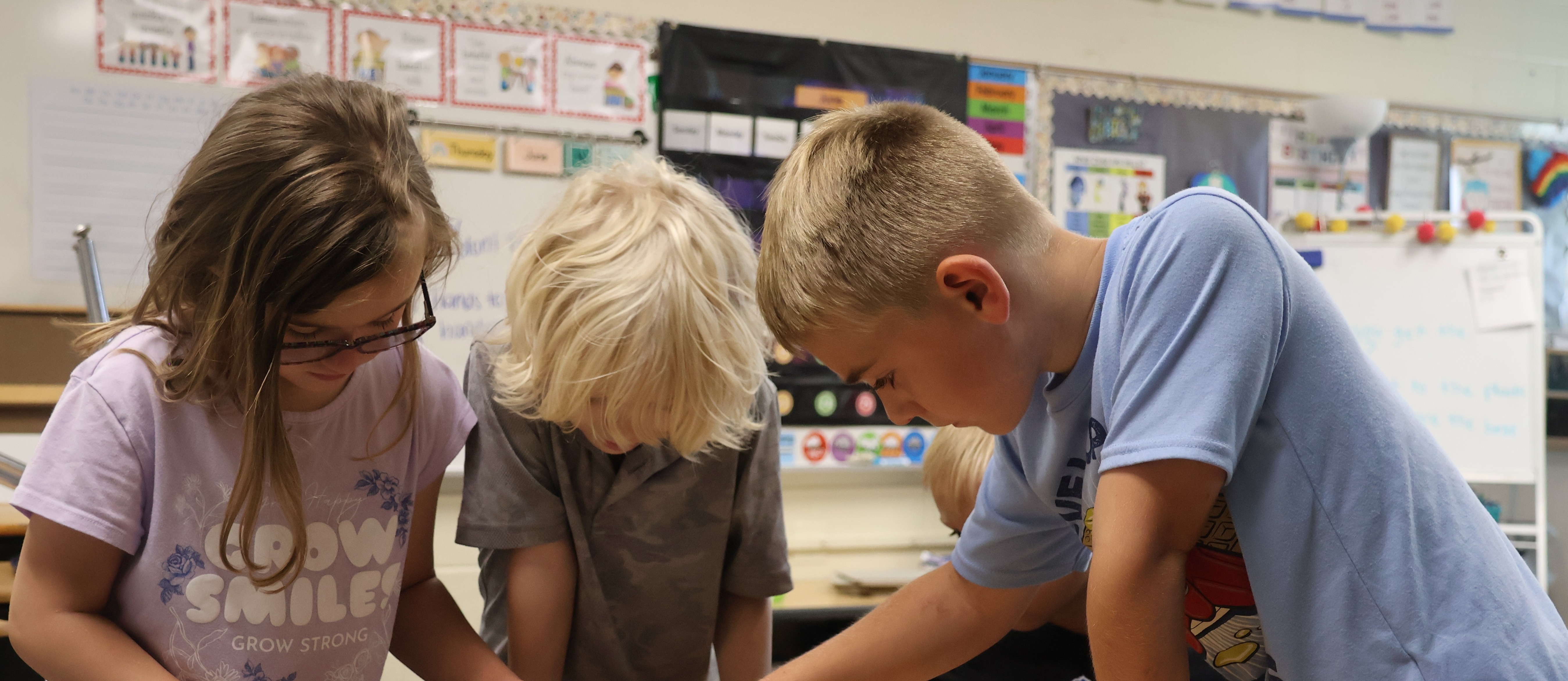 Picture of three students working together in a classroom on a science project 