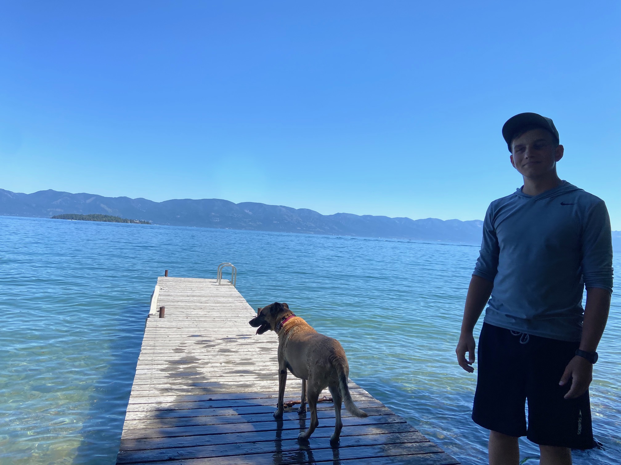 Photo of Tara Smart's husband and her dog on a dock over a lake