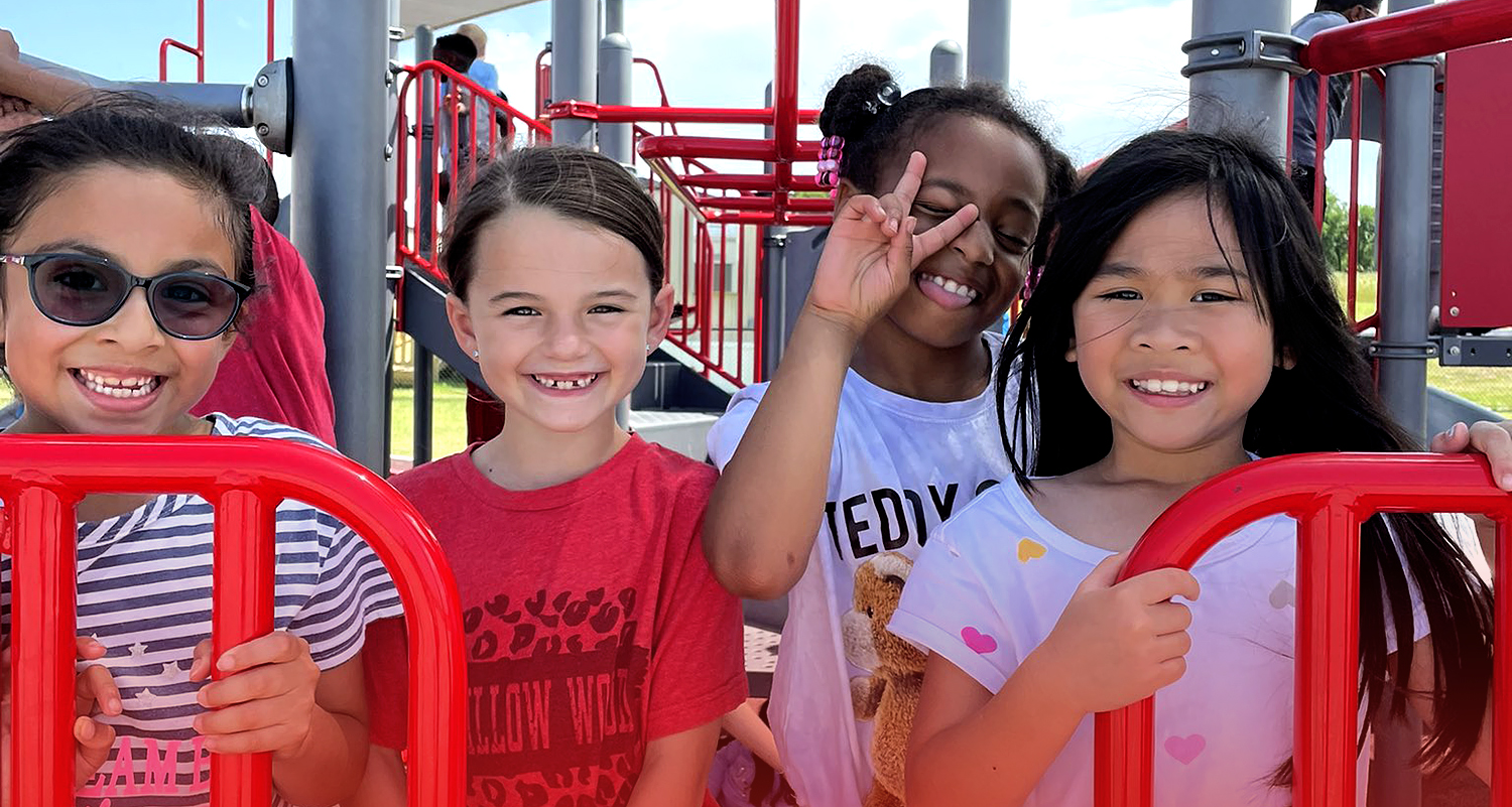 Four students on the playground at Willow Wood Elementary