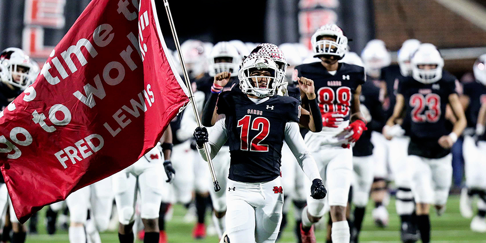 football players enter the field after exiting the tunnel