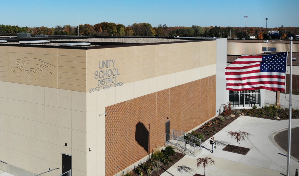 Exterior view of the Unity School District building with the school logo in the upper left corner.