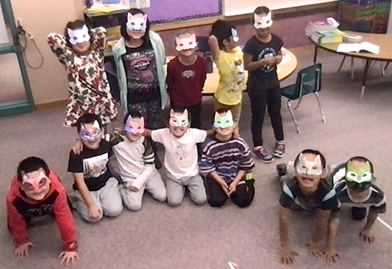 2nd grade students wearing the masks they made for Halloween.