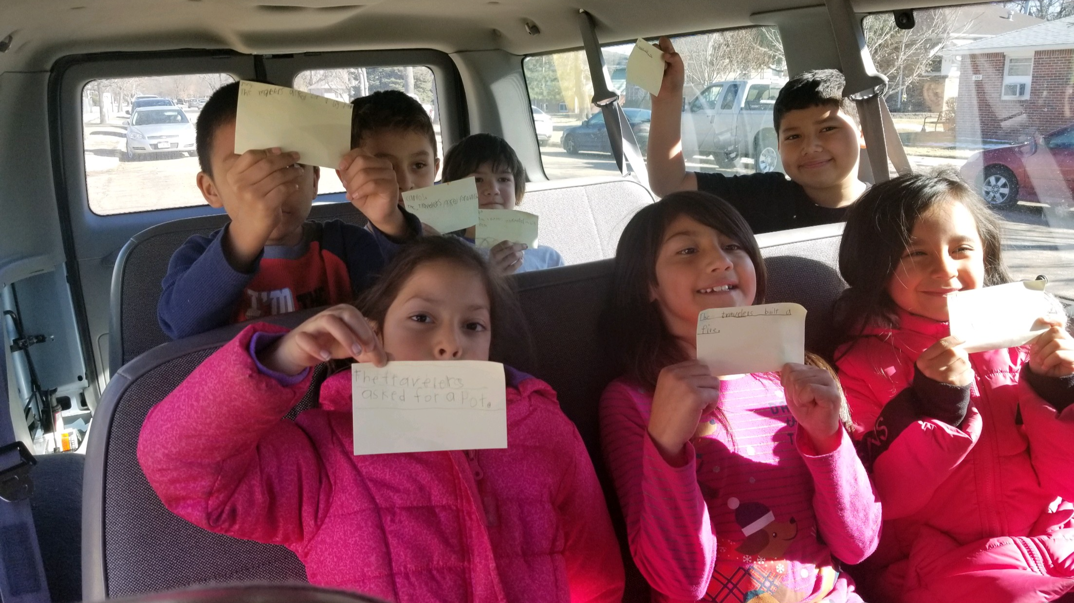 Students in a bus showing flashcards