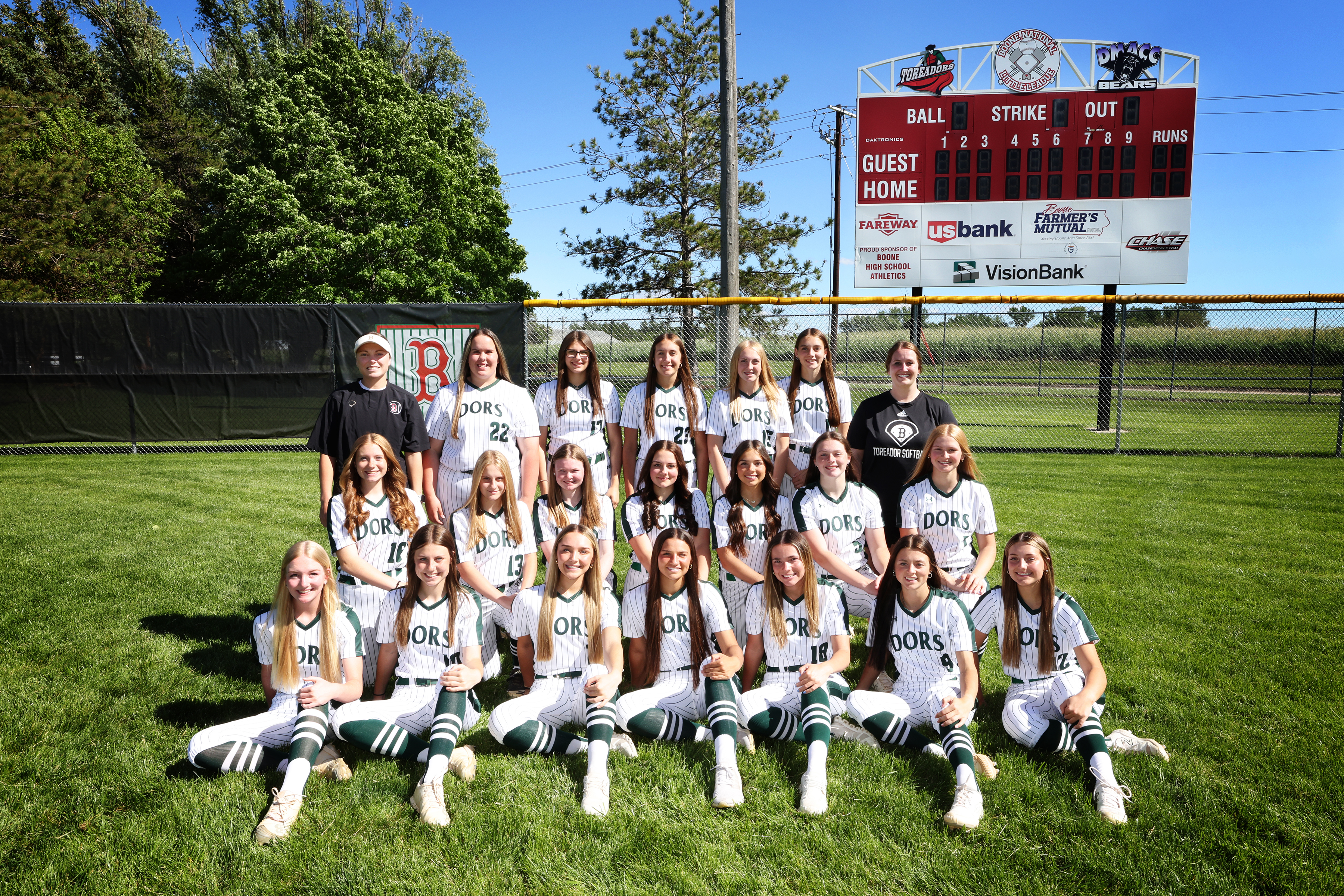 Softball girls on the softball field in front of scoreboard