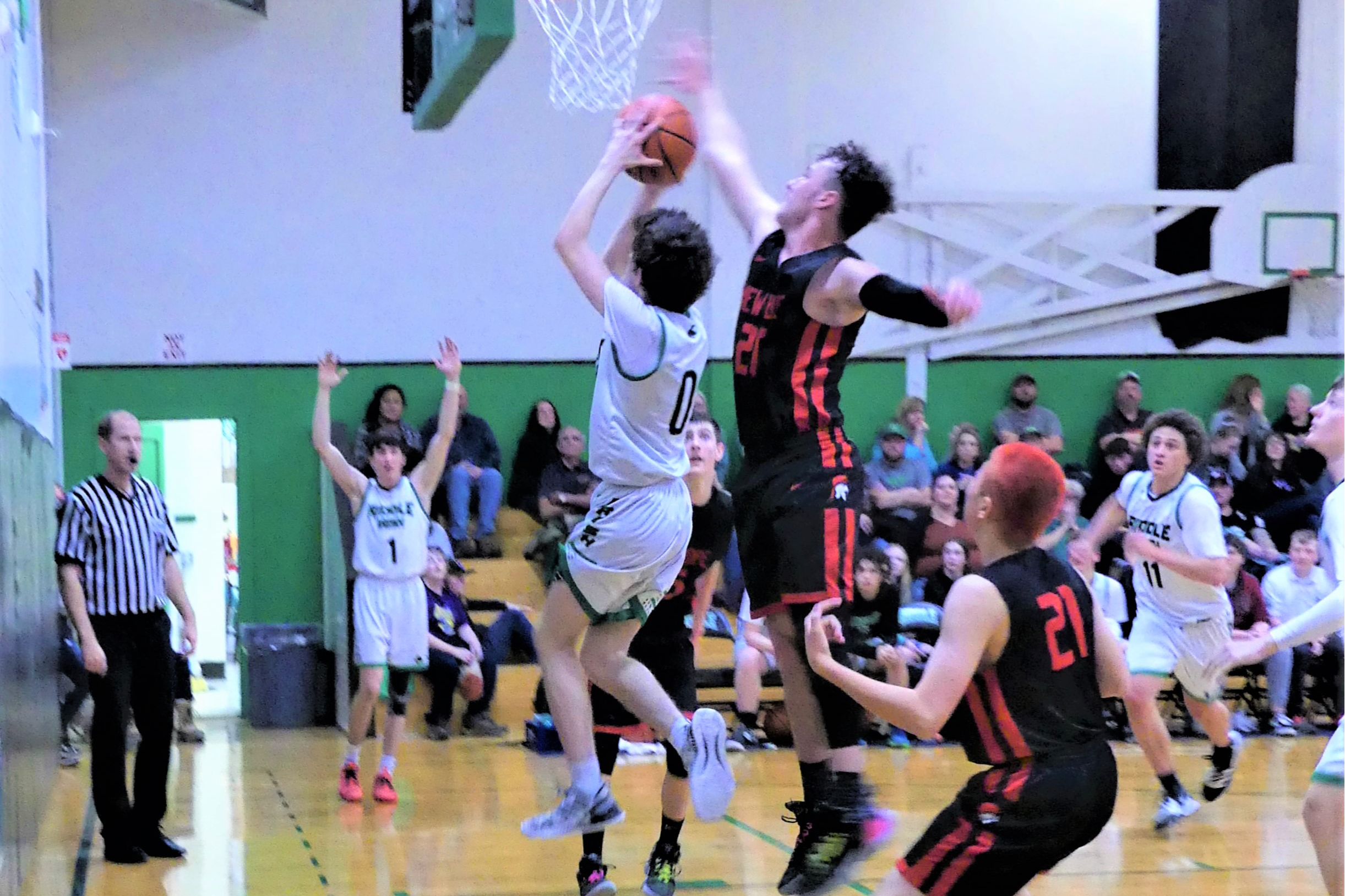 Riddle basketball player going up for a basket.