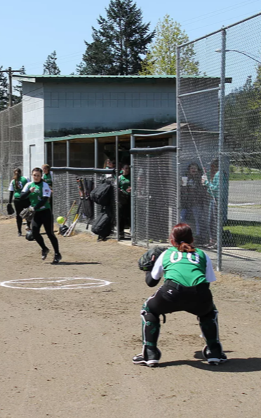 Softball players practice outside dugout