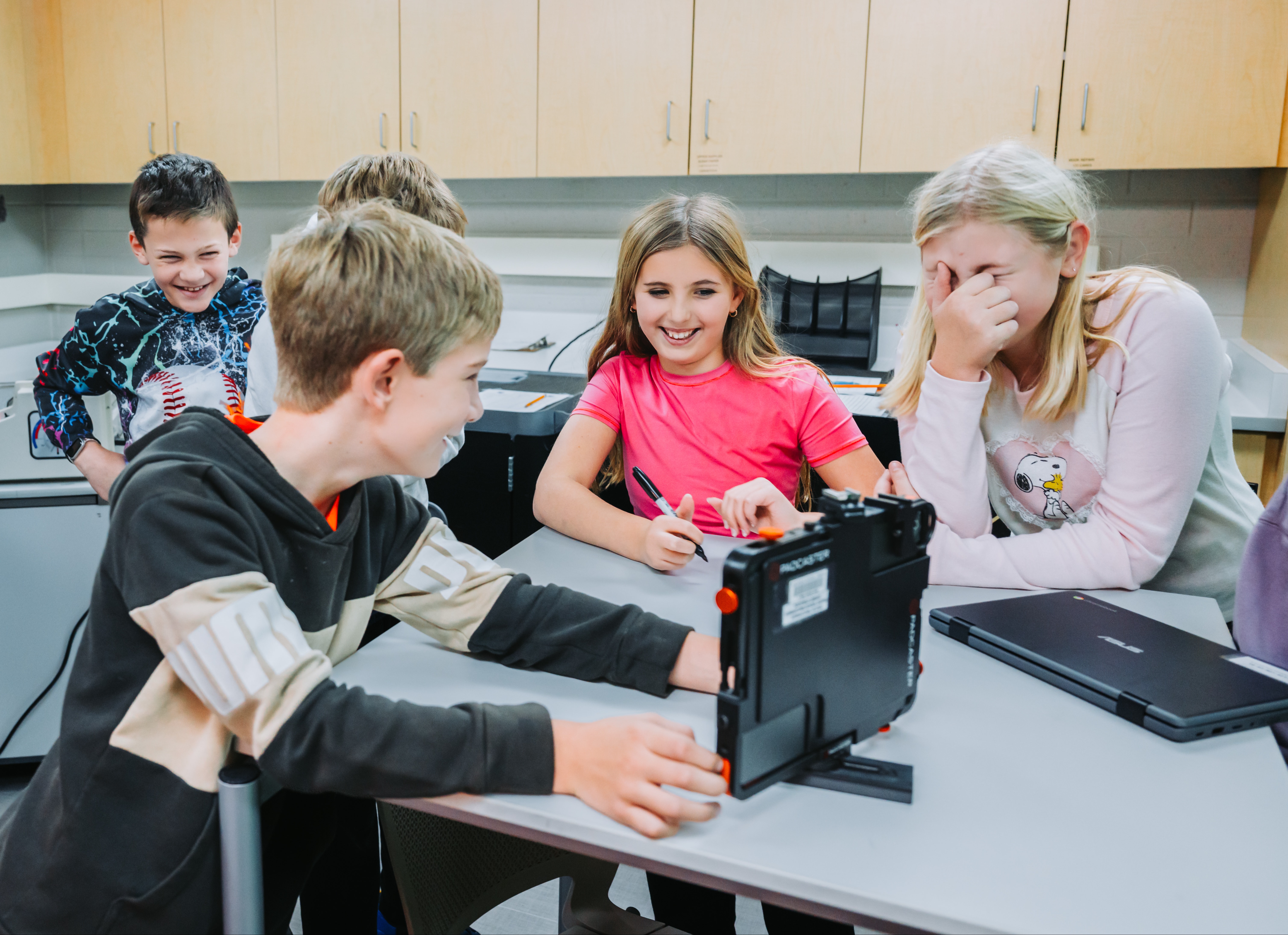 Three boys and two females enjoy working on a project together.