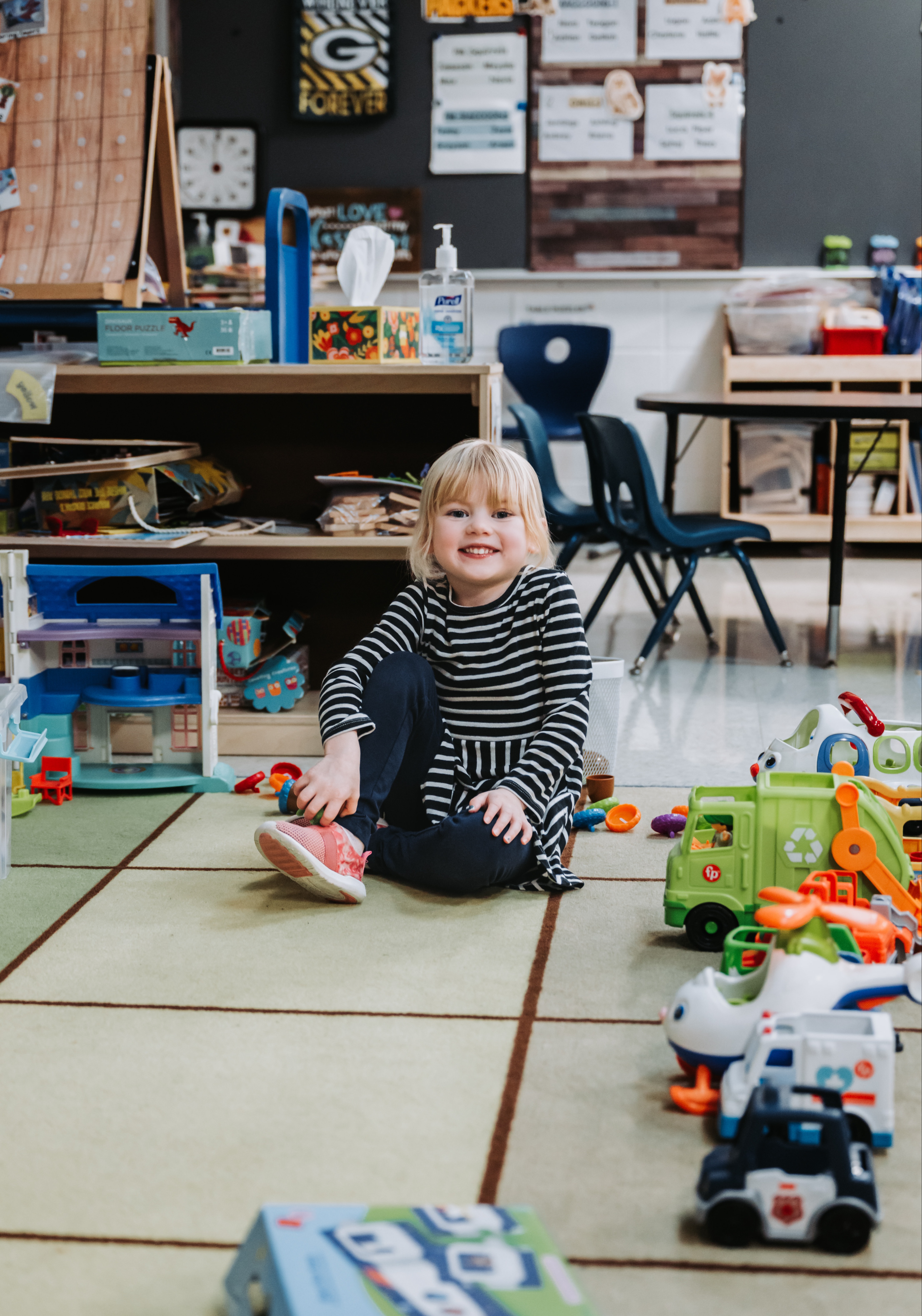 A student smiles while taking a quick break from playtime.