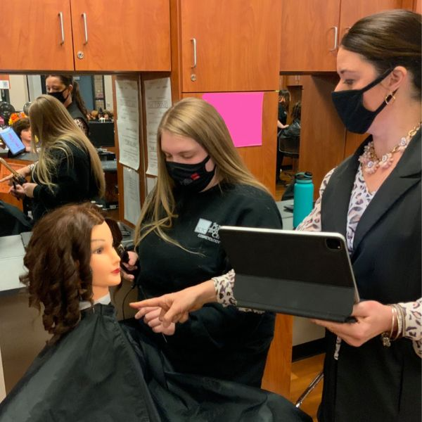 Student and instructor practicing hair styling