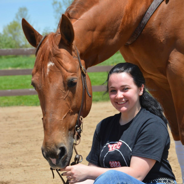 Student posing with horse